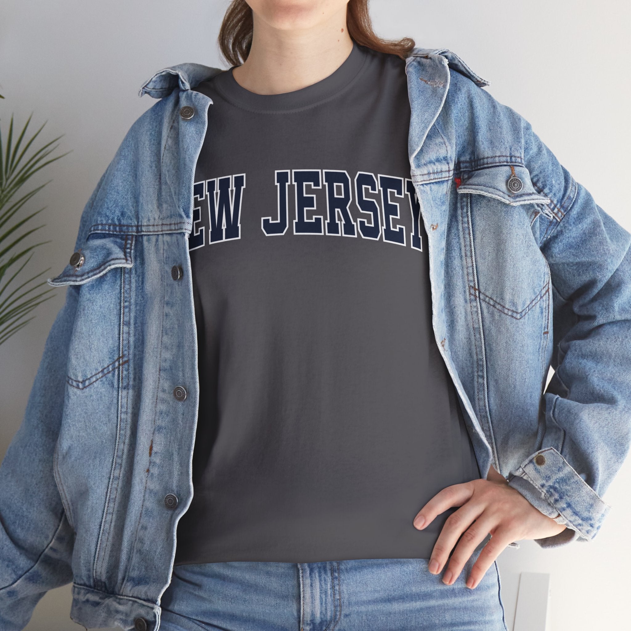 Person wearing a gray 'NEW JERSEY' t-shirt with a denim jacket indoors.
