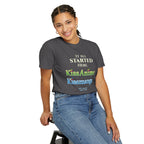 Person wearing a dark gray t-shirt with colorful text of KissAnime and Kissmanga, sitting on a stool against a white background