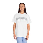 a woman wearing a white t-shirt with 'AMERICA EST. 1776' typography design in varsity style on a white background