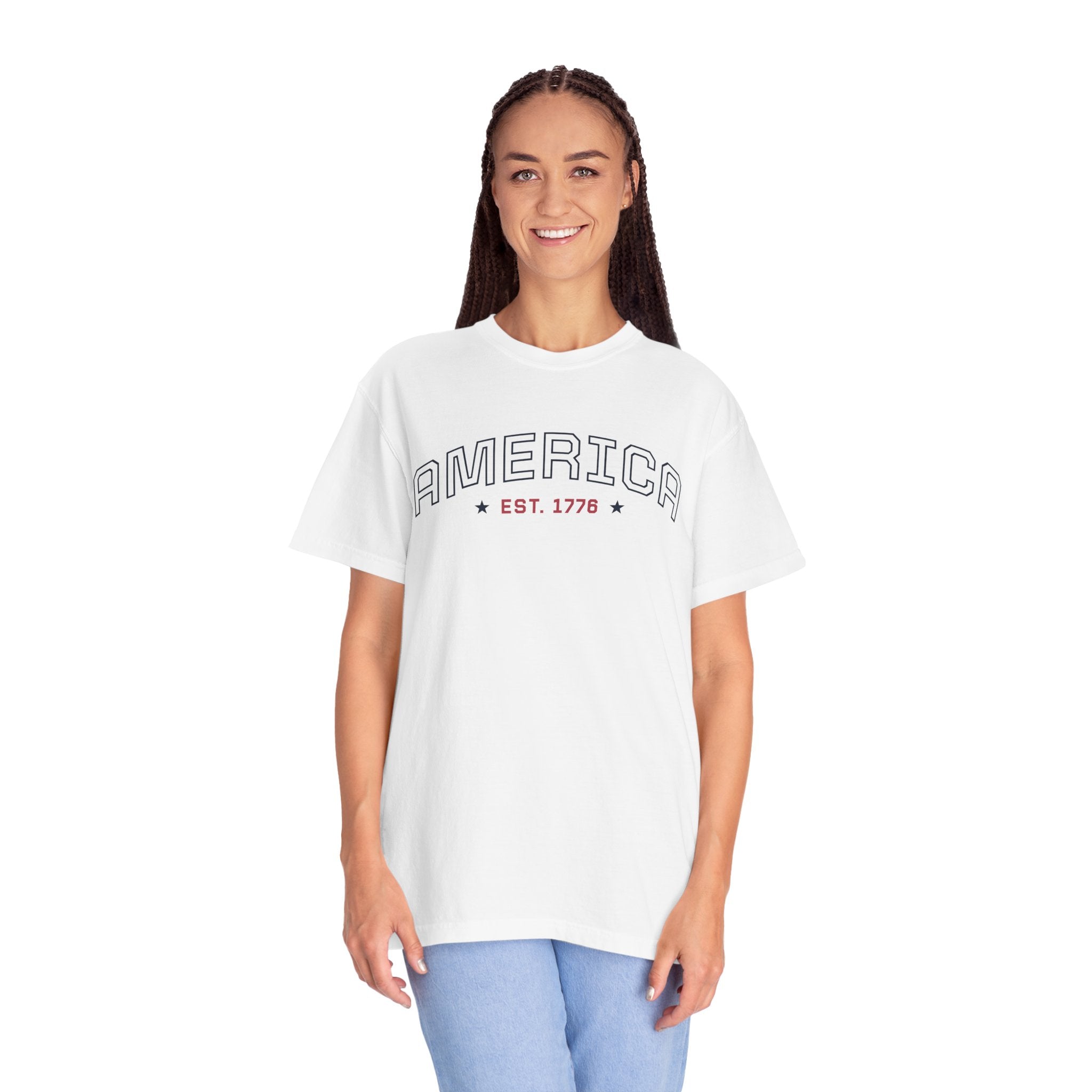 a woman wearing a white t-shirt with 'AMERICA EST. 1776' typography design in varsity style on a white background