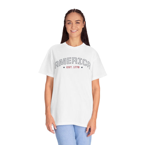 a woman wearing a white t-shirt with 'AMERICA EST. 1776' typography design in varsity style on a white background