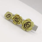 Hair clip with three gold rose flowers on a white background