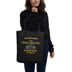 Person holding a black tote bag with yellow text on a white background