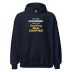 Navy blue hoodie with humorous 'I'm Not Ignoring You, I'm Reading the New Chapter' text design on a white background