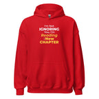 Red hoodie with funny otaku manga text 'I'm Not Ignoring You, I'm Reading the New Chapter' on a white background