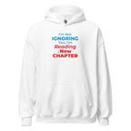 White hoodie with text 'I'm Not Ignoring You, I'm Reading a New Chapter' on a white background