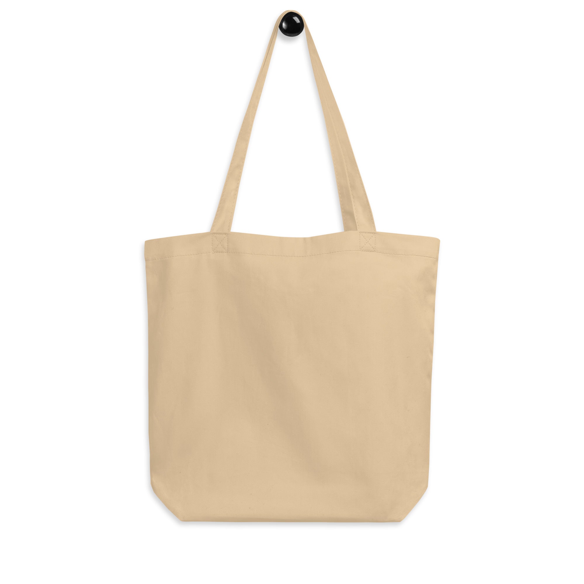 Beige tote bag with a black button on a white background