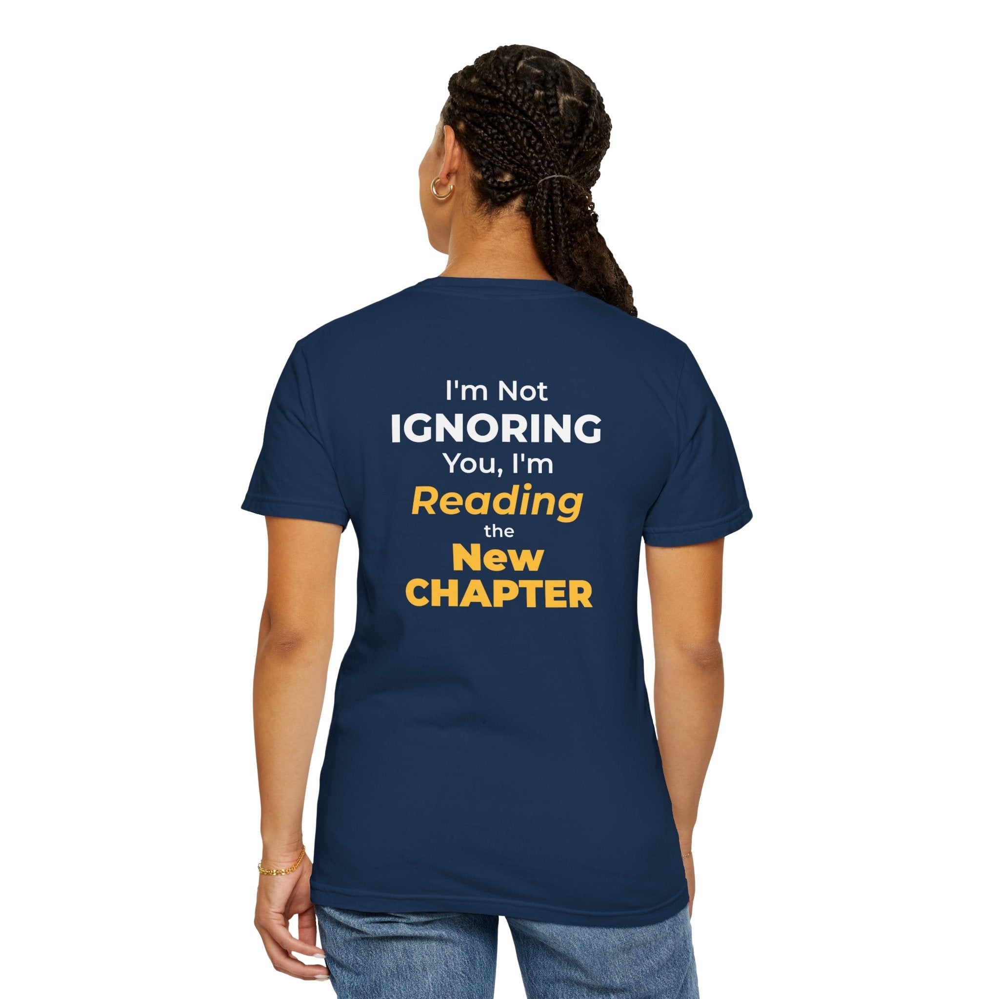 A woman wearing black t-shirt with text 'I'm Not Ignoring You, I'm Reading the New Chapter' on the back side on a white background