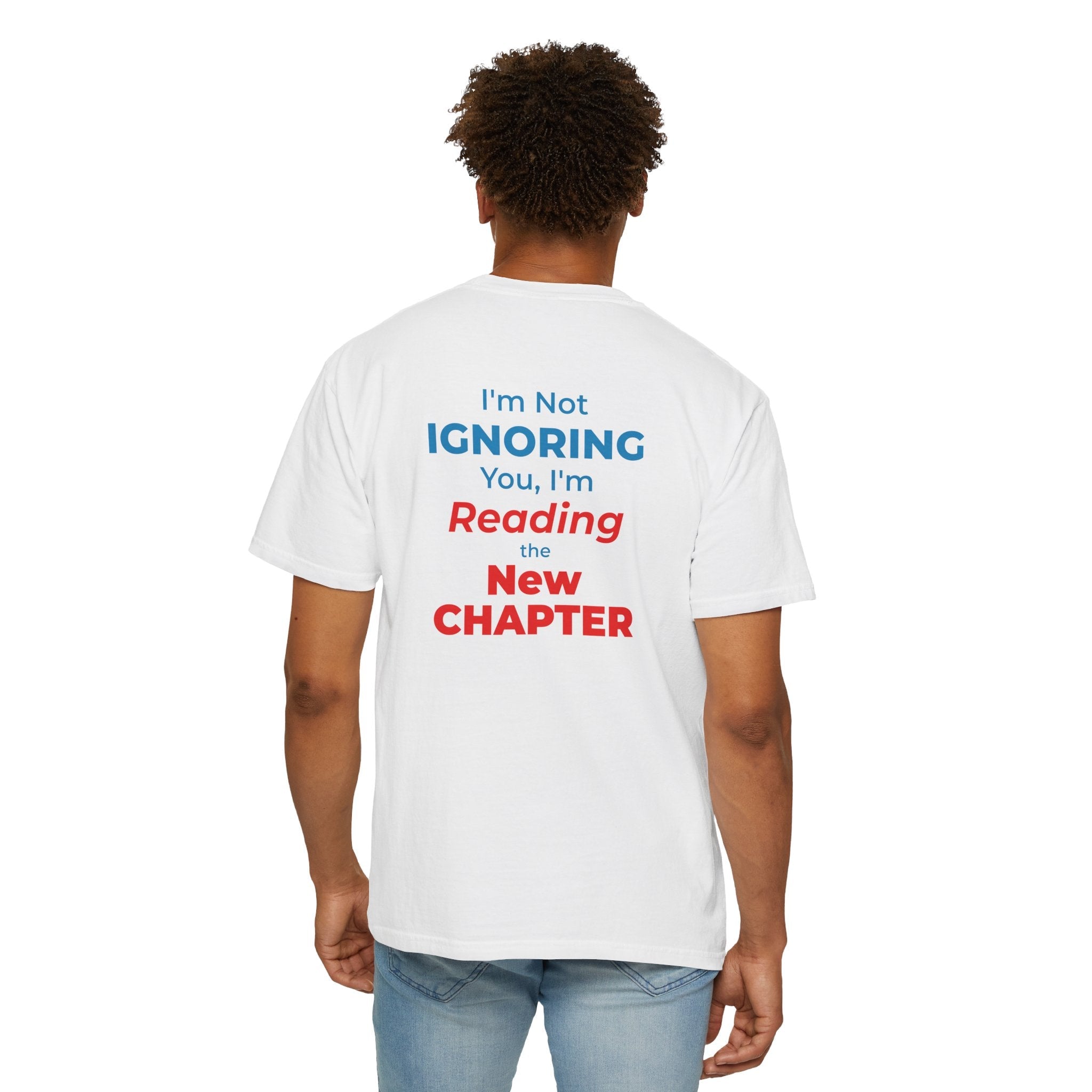 A man wearing white t-shirt with text 'I'm Not Ignoring You, I'm Reading the New Chapter' on the back side on a white background