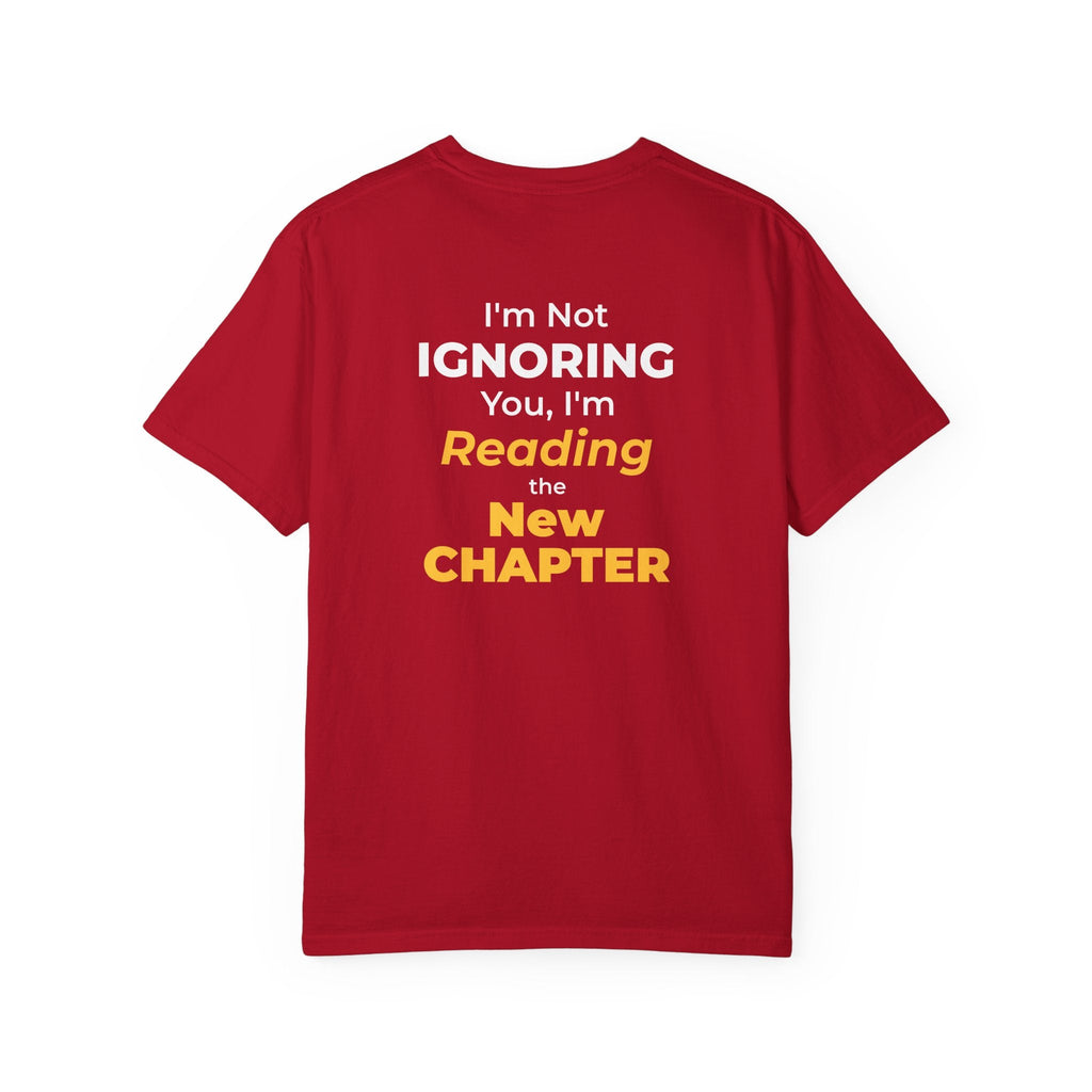 Red t-shirt with text 'I'm Not Ignoring You, I'm Reading the New Chapter' on the back side on a white background