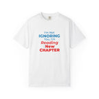 White t-shirt with text 'I'm Not Ignoring You, I'm Reading the New Chapter' on a white background