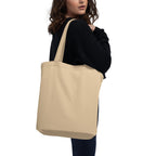 a woman carrying a beige tote bag on her shoulder