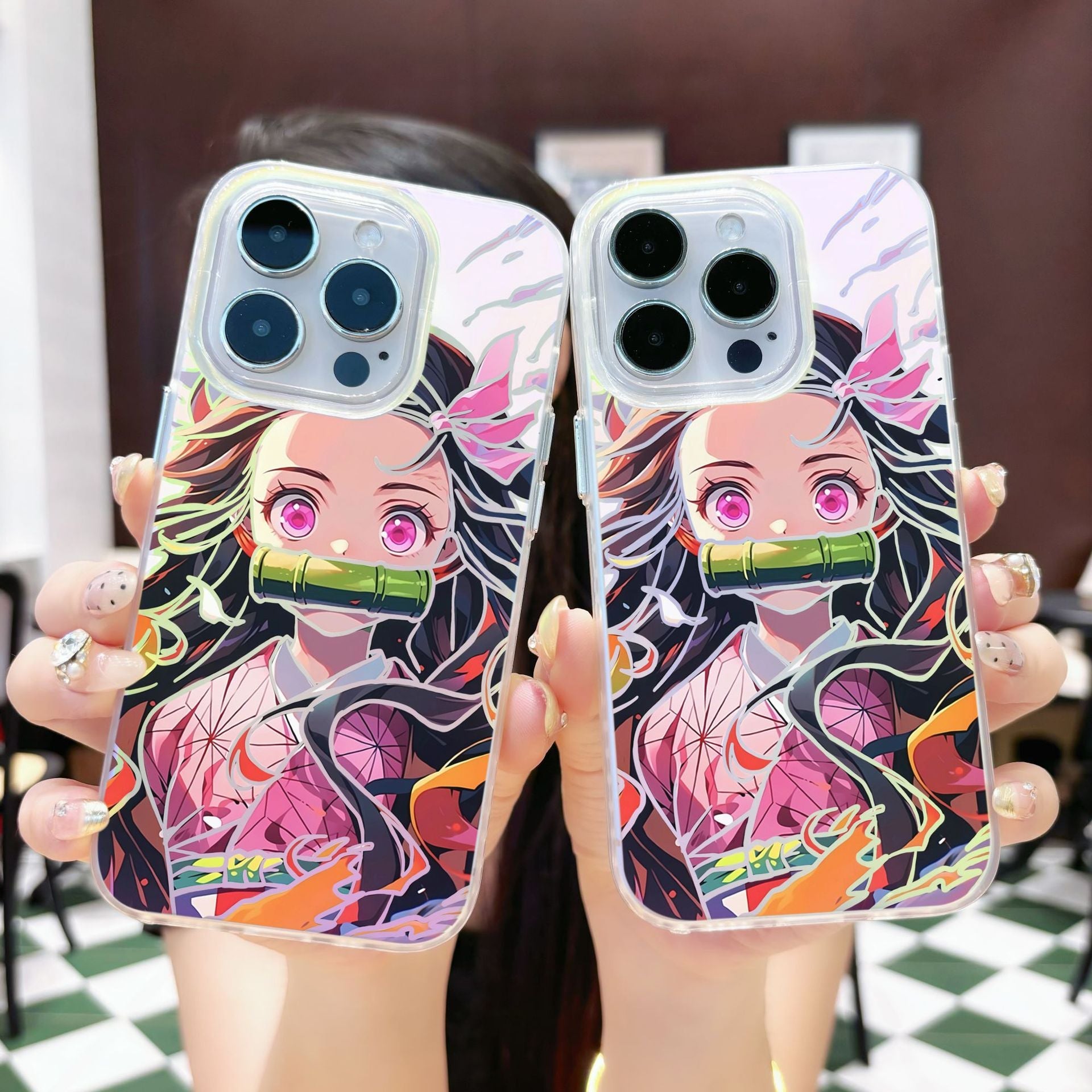 Two phone cases with an anime Kimetsu No Yaiba Demon Slayer Nezuko Kamado character design held by a person.