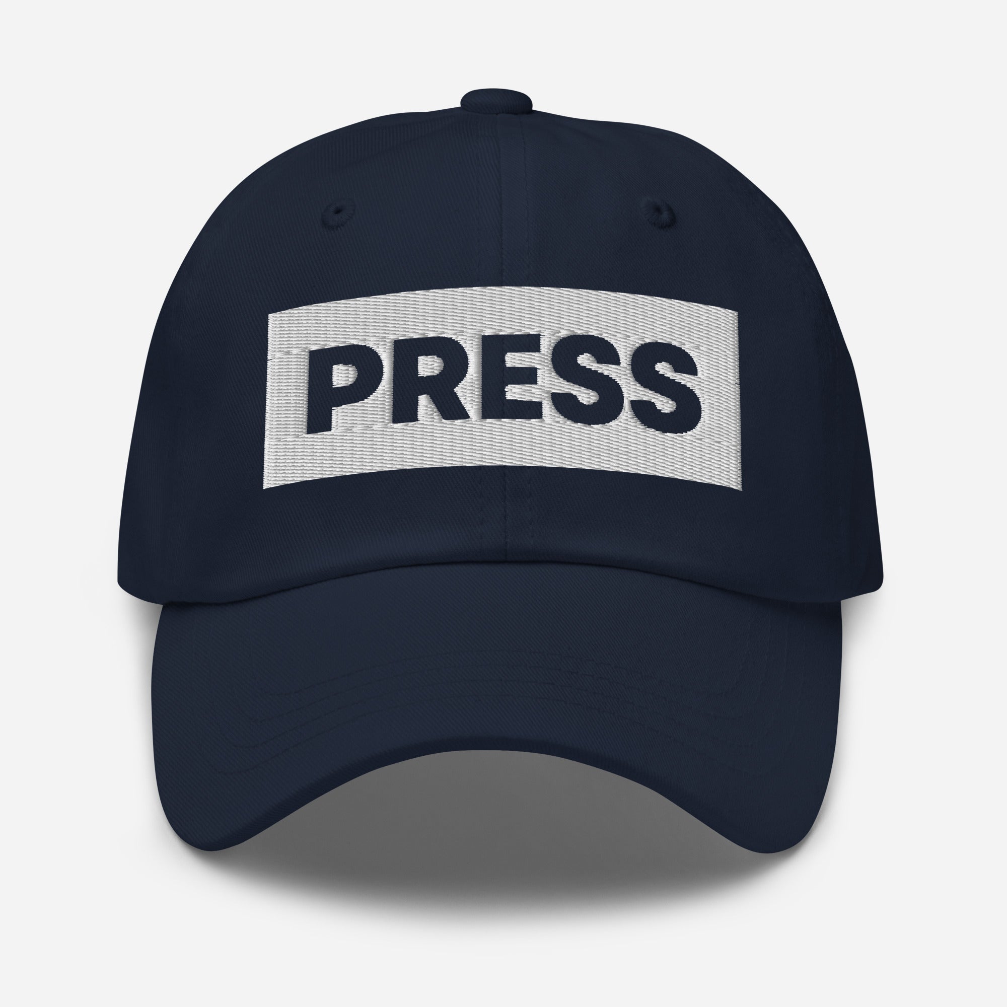 Navy blue cap with 'PRESS' embroidered logo on a light gray background