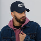 Man wearing a navy 'PRESS' embroidered cap against a gray background