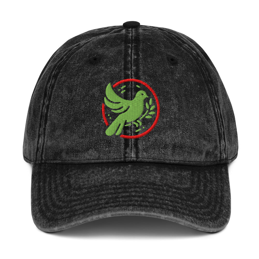 Black denim cap with a green dove and red circle logo on a white background