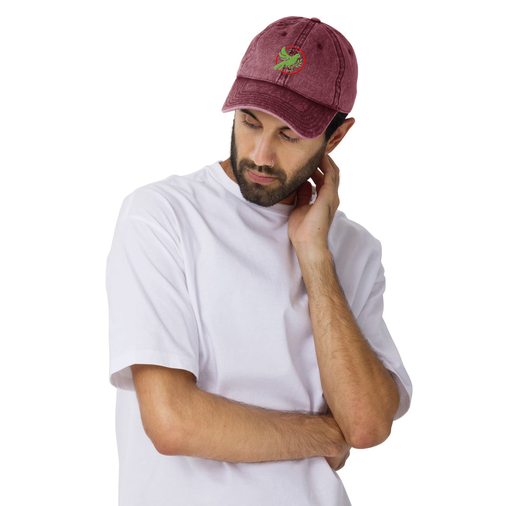 A man wearing a maroon cap with a bird logo on a white background