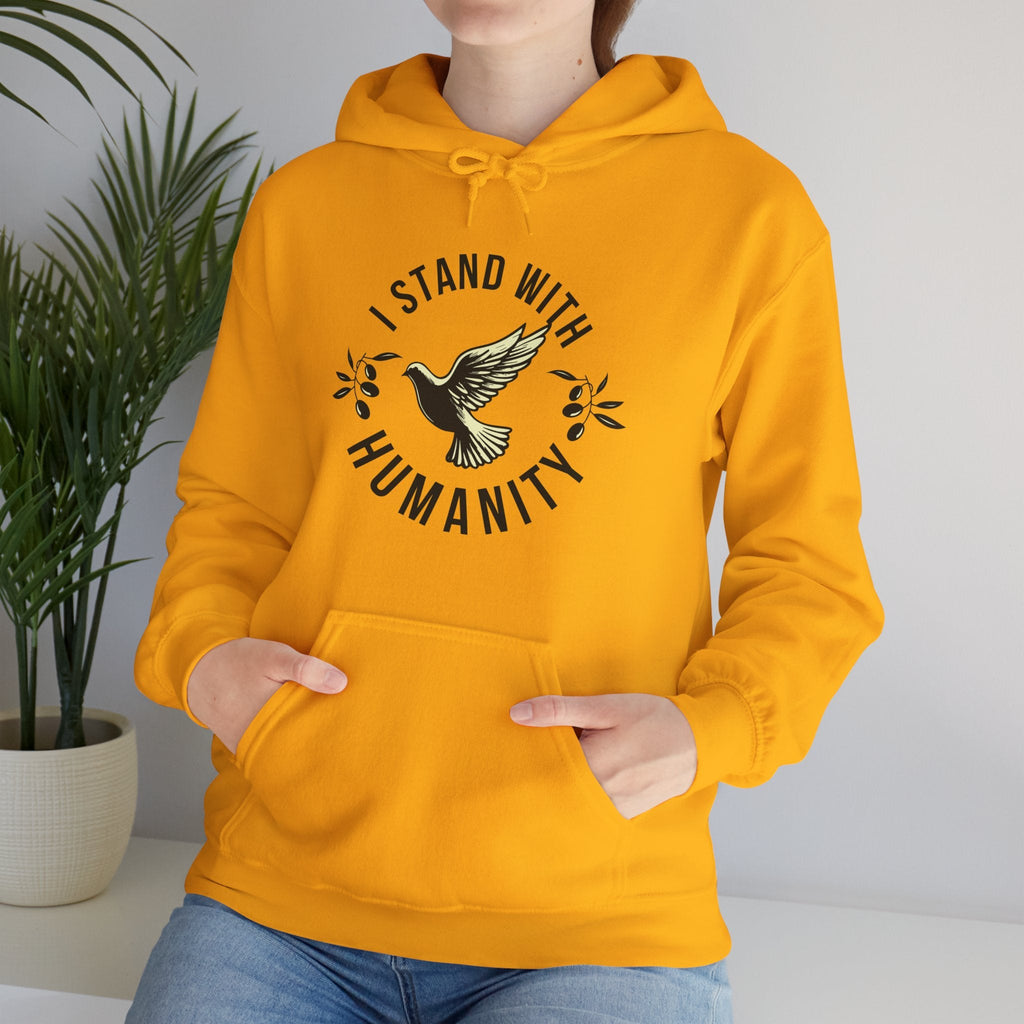 Person wearing a gold hoodie with 'I Stand With Humanity' design, standing against a plain background.