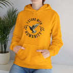Person wearing a gold hoodie with 'I Stand With Humanity' design, standing against a plain background.