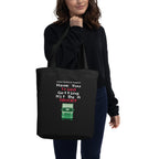 Person holding a black tote bag with humorous text design.