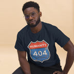 Man wearing a navy blue t-shirt with a 'Humanity 404 Not Found' graphic design on a beige background