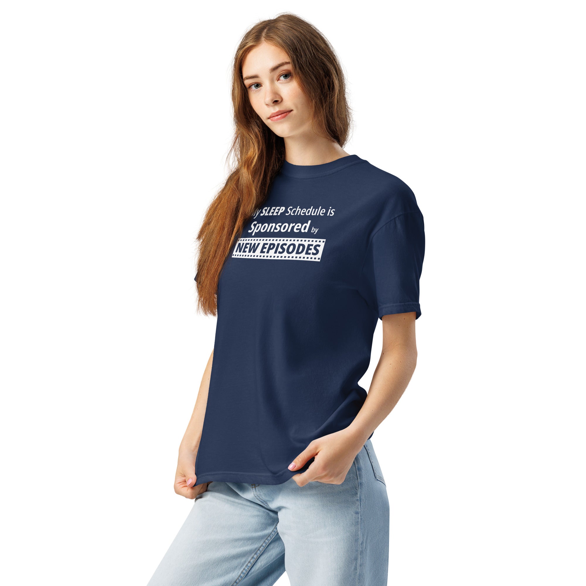 Person wearing a navy blue t-shirt with funny, witty 'My Sleep Schedule is Sponsored by New Episodes' text design on a white background